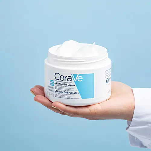 Dermatologist holding a CeraVe SA Smoothing Cream pot in their palm